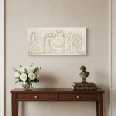 Apollo And Muse Frieze Wall Decor Decorative console table with flowers and sculptures against a wall with framed art