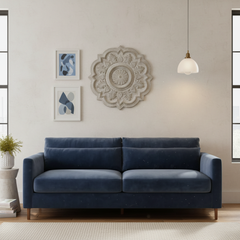 Blue sofa in a living room with decorative wall art and a pendant light.