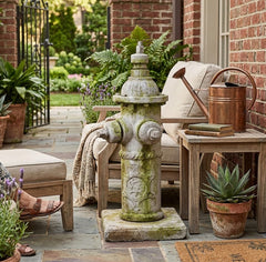 Decorative stone fire hydrant on a patio with plants and furniture