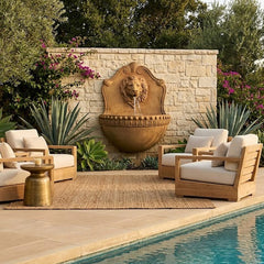 Outdoor patio area with furniture and a lion head fountain by a pool.