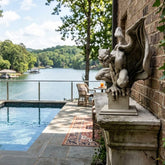 Gargoyle statue by a pool with a scenic lake view