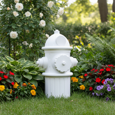 White fire hydrant in a garden with flowers and greenery
