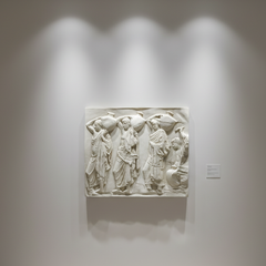 White relief sculpture on a wall in a museum setting