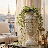 Decorative urn with ivy on a table with a cityscape view in the background