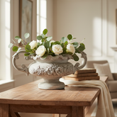 Decorative vase with flowers on a wooden table in a living room.