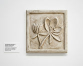 Decorative stone plaque with floral design on a white wall