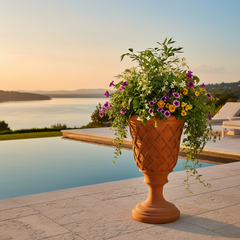 Decorative urn with flowers by a poolside at sunset