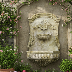 Decorative stone wall fountain with floral and greenery around