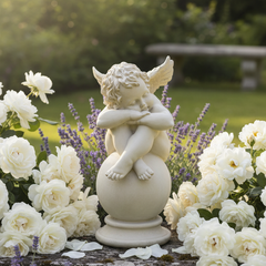 Statue of a cherub surrounded by white flowers in a garden setting