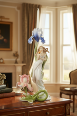 Decorative figurine of a woman holding flowers on a wooden table in a room with a fireplace and window.