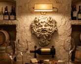 Wine cellar with wine bottles, glasses, and a decorative wall mask Wall Bacchus 10 Small Wall Plaque Sculpture