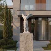 Statue of a winged figure on a pedestal in front of a modern house