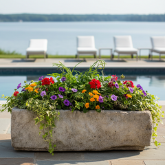 Floral arrangement in a stone planter by a pool with lounge chairs and a lake view Trough Doolin 10" — Planter Sculpture