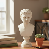 White marble bust on a wooden table with books and a plant