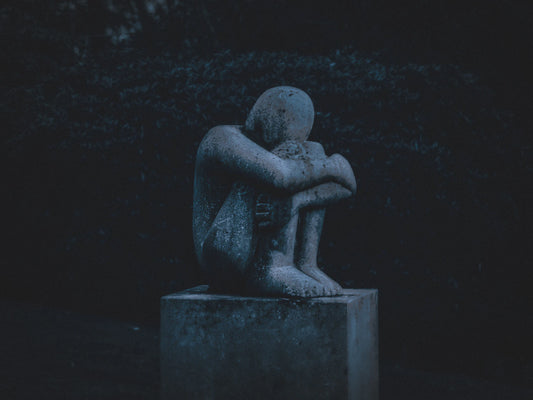 A stone outdoor garden statue of a man.
