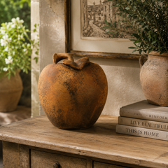 Decorative object on a wooden table with books and plants in the background