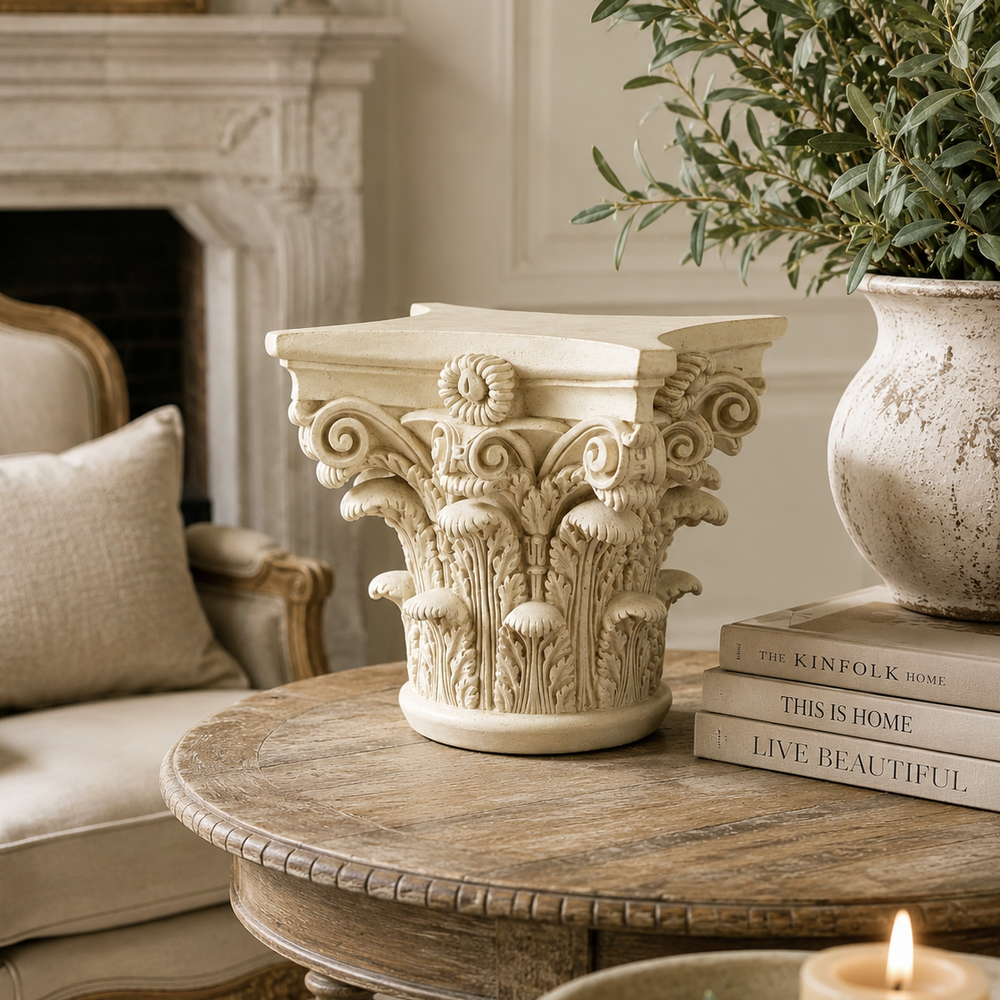 Decorative table with classical column design, books, and a candle in a living room setting.
