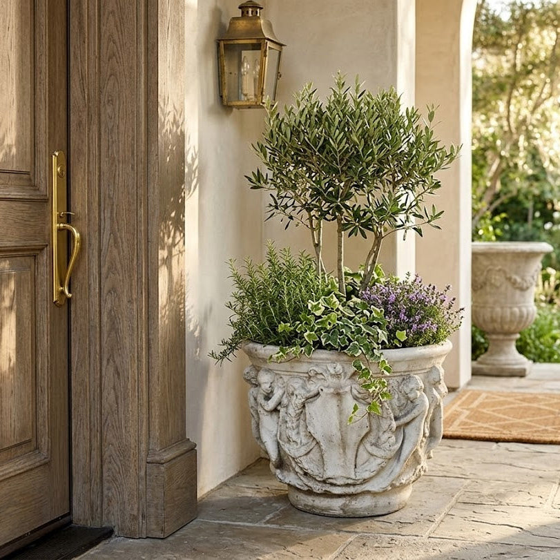 Decorative planter with greenery in front of a wooden door on a patio Elegant Cherub Bell Pot — Planter 