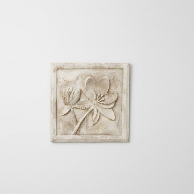 Decorative wall art with floral design on a plain white wall.