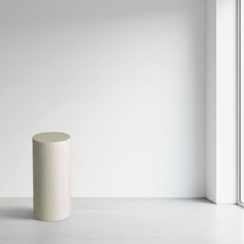 Cylindrical concrete block on a white floor with a light gray wall background