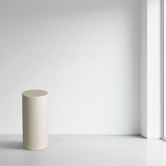 Cylindrical concrete block on a white floor with a light gray wall background