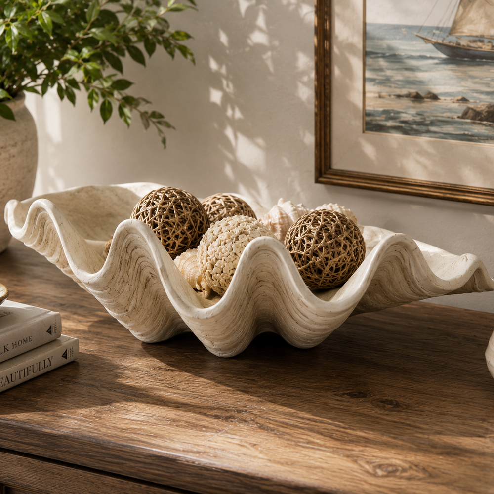 Decorative shell bowl with natural elements on a wooden surface, framed picture in the background