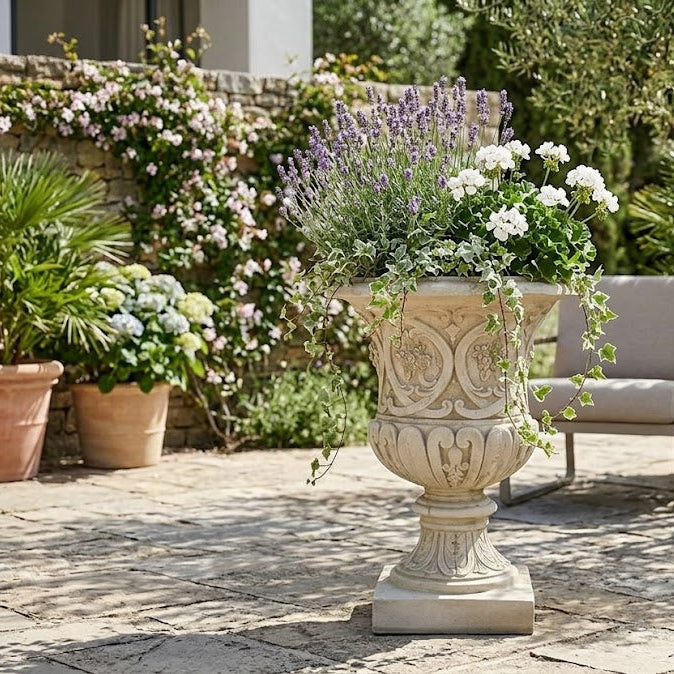 Decorative urn with plants on a patio with chairs and lanterns