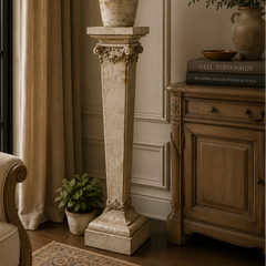 Living room with a decorative column, potted plants, and a cabinet.