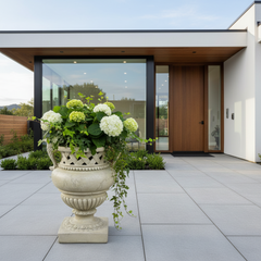 Decorative urn with flowers in front of a modern house