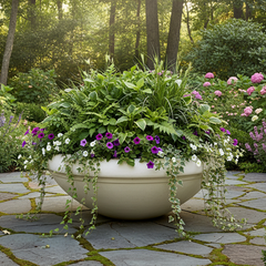 Decorative garden with a large planter filled with flowers and plants on a stone patio.
