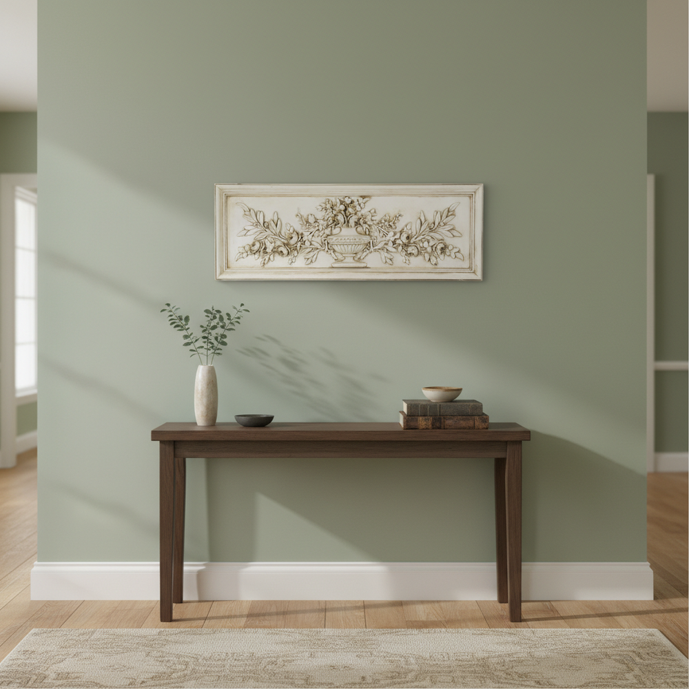 Wooden console table against a green wall with a decorative painting above it.