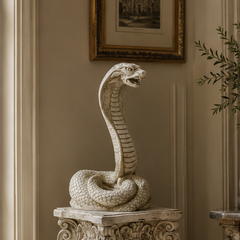 Decorative snake sculpture on a pedestal in an elegant room with a chair and table.