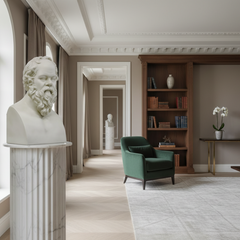 Luxurious interior with a green armchair, bookshelf, and classical statue.