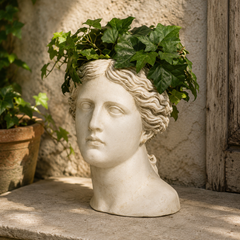 Marble bust of a classical figure with ivy on a stone surface
