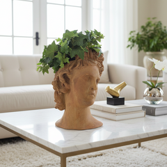 Decorative head planter with greenery on a coffee table in a living room setting.