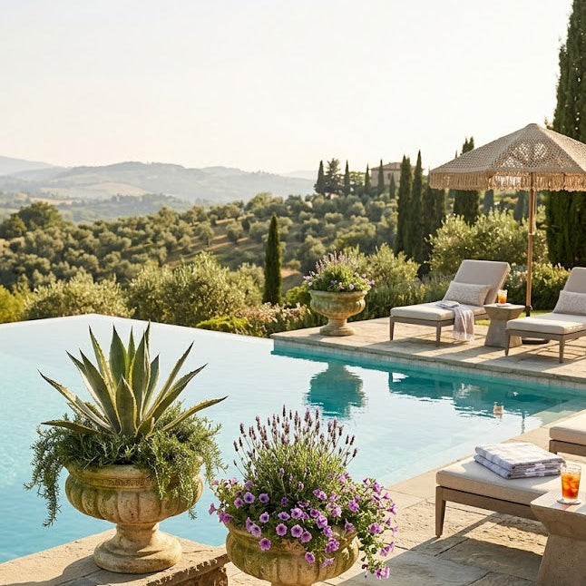 Outdoor pool area with lounge chairs, umbrellas, and decorative plants in Tuscany.
