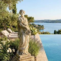 Statue by a pool with a scenic view of water and trees