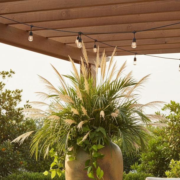 Outdoor patio with furniture, plants, and a large vase.