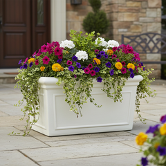 White planter box with colorful flowers on a patio