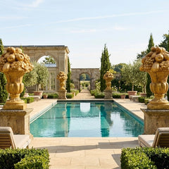 Luxurious outdoor setting with a pool, decorative urns, and manicured gardens.
